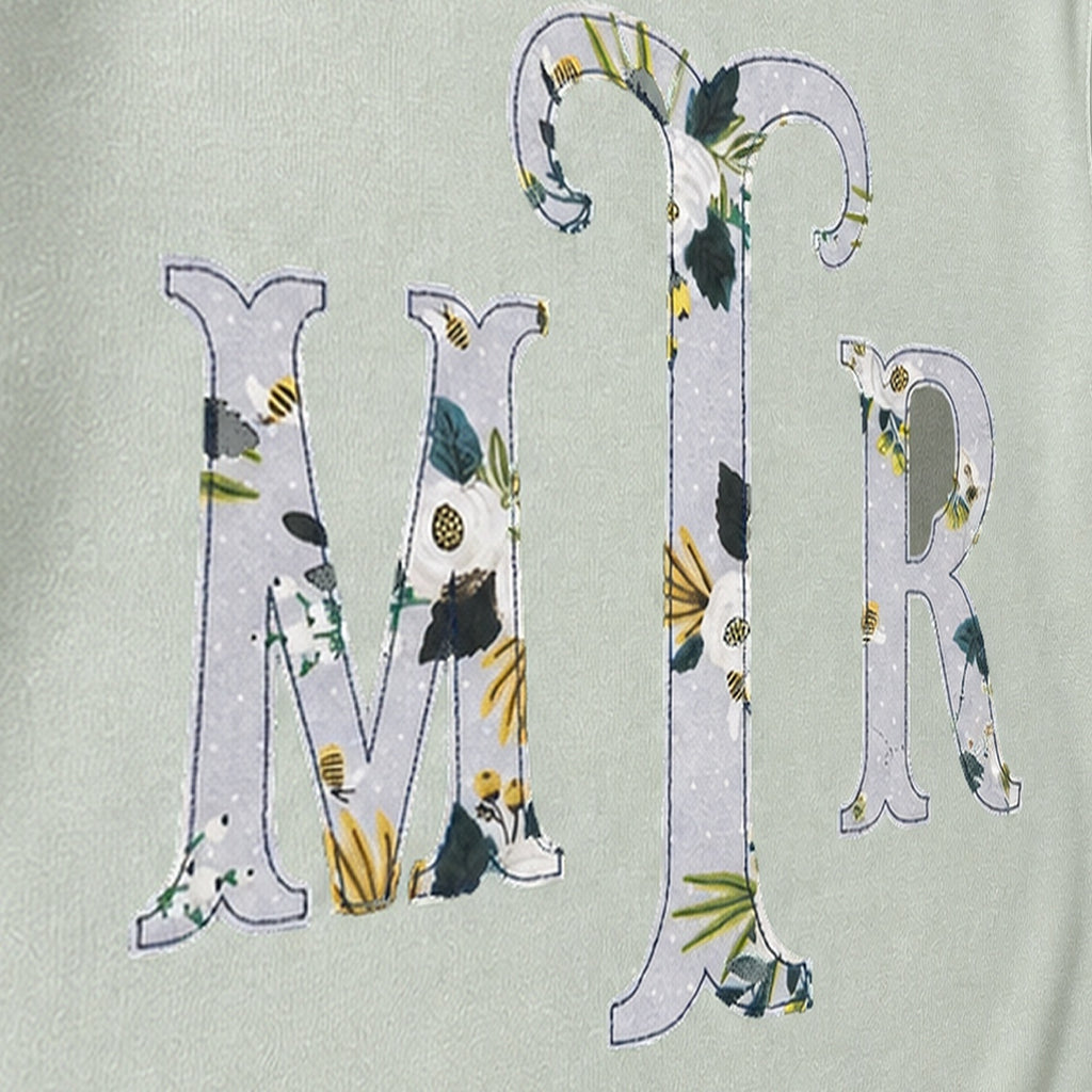 Close-up of the embroidered design on a custom botanical floral serif monogram crewneck sweatshirt