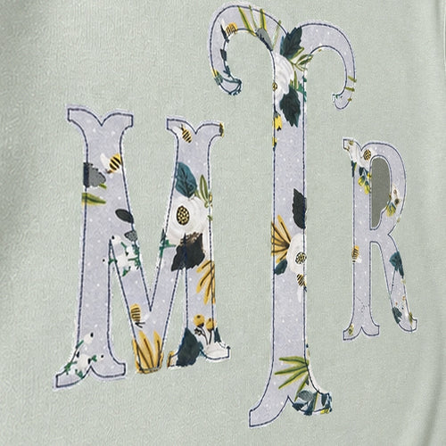 Close-up of the embroidered design on a custom botanical floral serif monogram crewneck sweatshirt