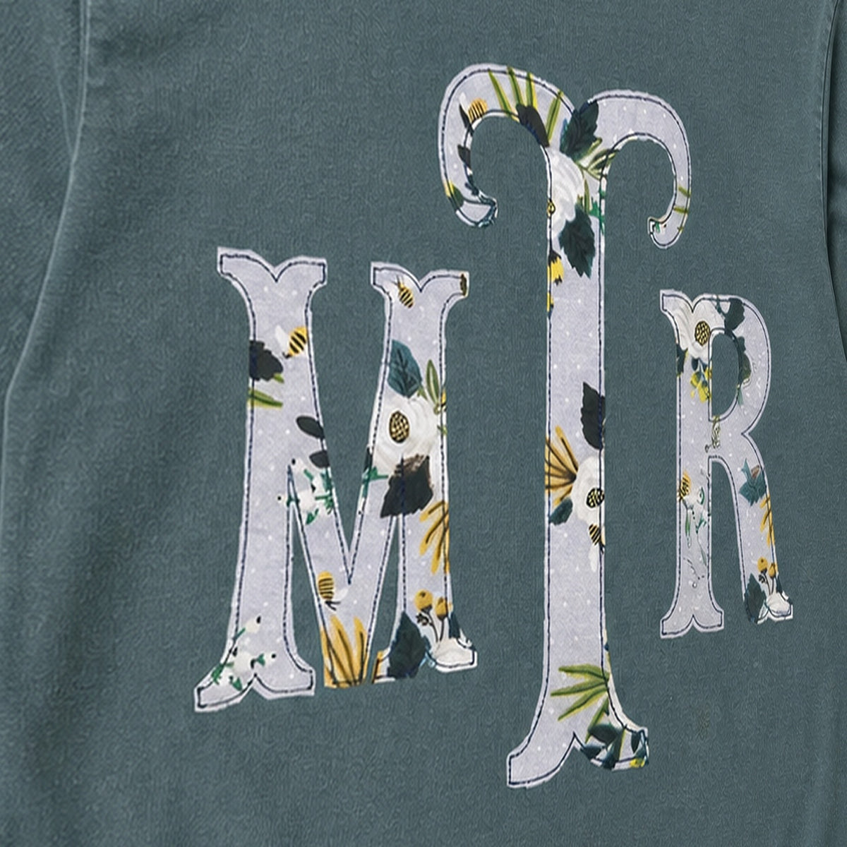 Close-up of the embroidered design on a custom botanical floral serif monogram long sleeve shirt
