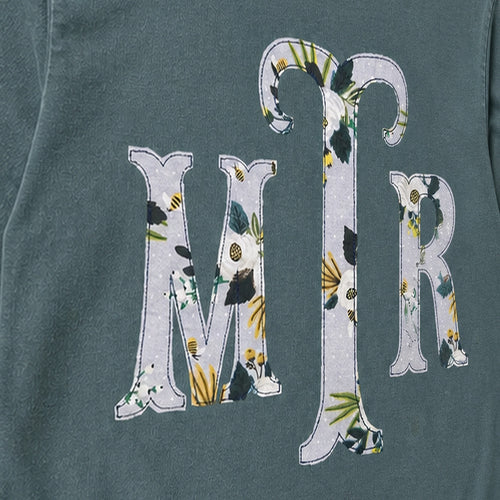 Close-up of the embroidered design on a custom botanical floral serif monogram long sleeve shirt