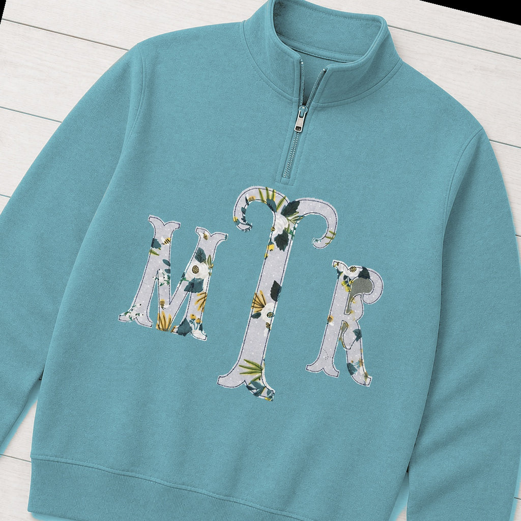 Custom botanical floral serif monogram quarter zip pullover folded flat lay