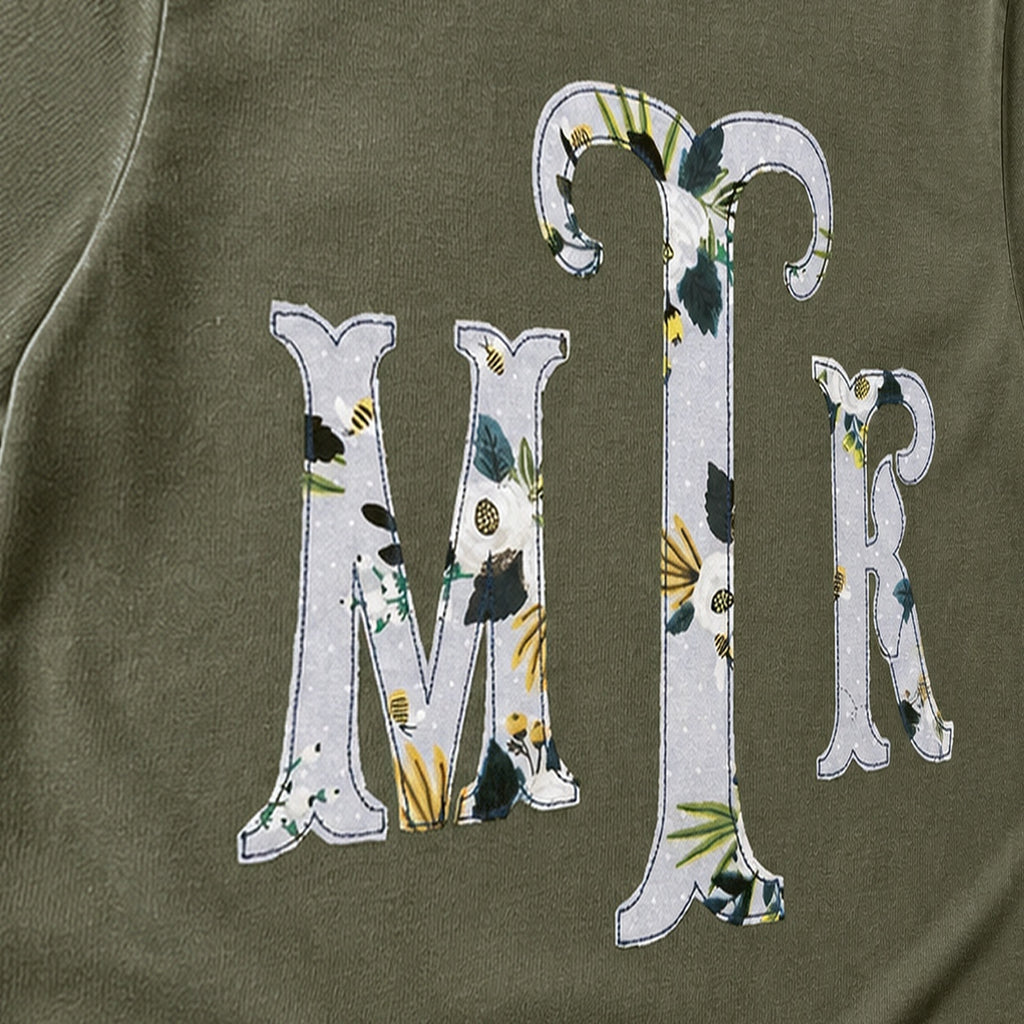 Close-up of the embroidered design on a botanical floral serif monogram shirt