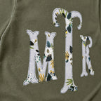 Close-up of the embroidered design on a botanical floral serif monogram shirt