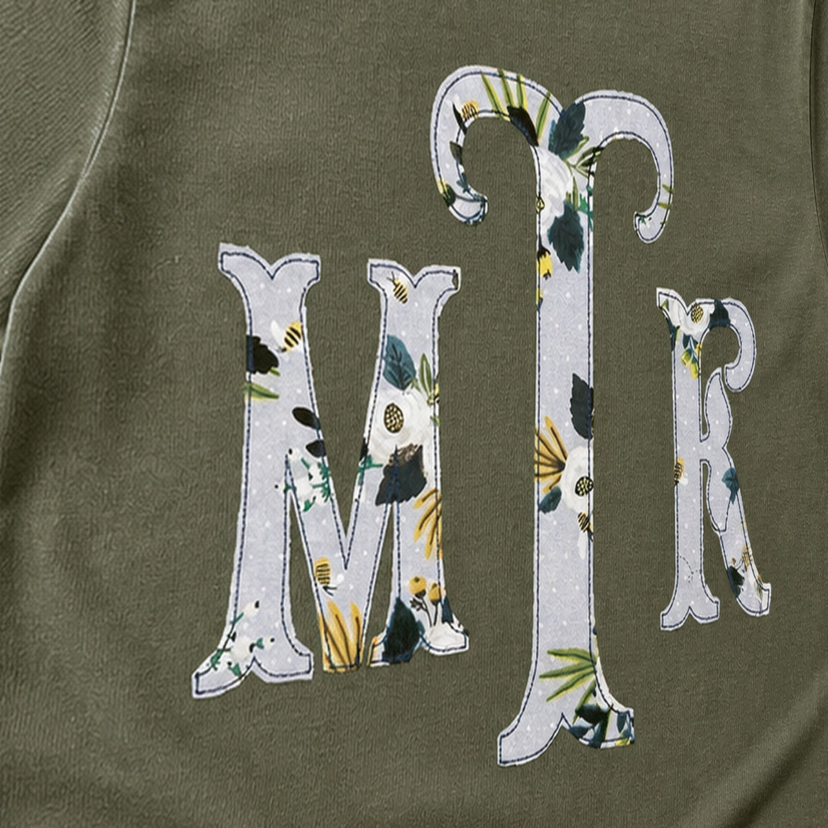 Close-up of the embroidered design on a botanical floral serif monogram shirt