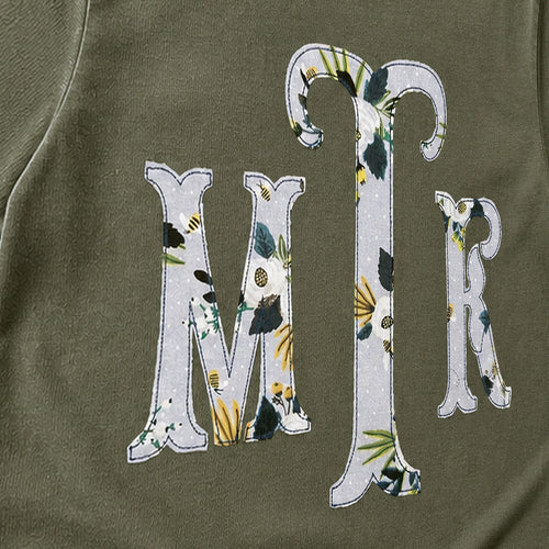 Close-up of the embroidered design on a botanical floral serif monogram shirt
