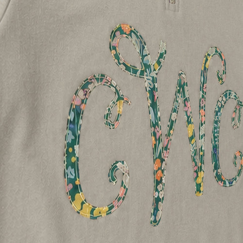 Close-up of the embroidered design on a custom floral vine monogram quarter zip pullover