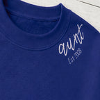 Close-up of the embroidered design on a aunt established sweatshirt with sleeve names