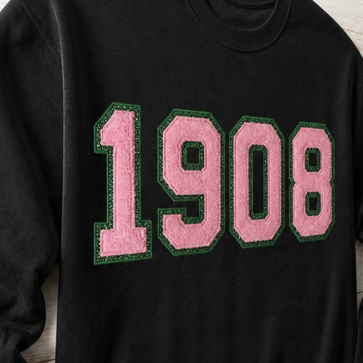 Close-up of the embroidered design on a 1908 faux chenille glitter crewneck sweatshirt