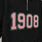 Close-up of the embroidered design on a 1908 faux chenille glitter quarter zip pullover