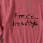 Close-up of enlarged black First of all... I'm a delight. embroidery on Comfort Colors G1580 Crimson quarter-zip