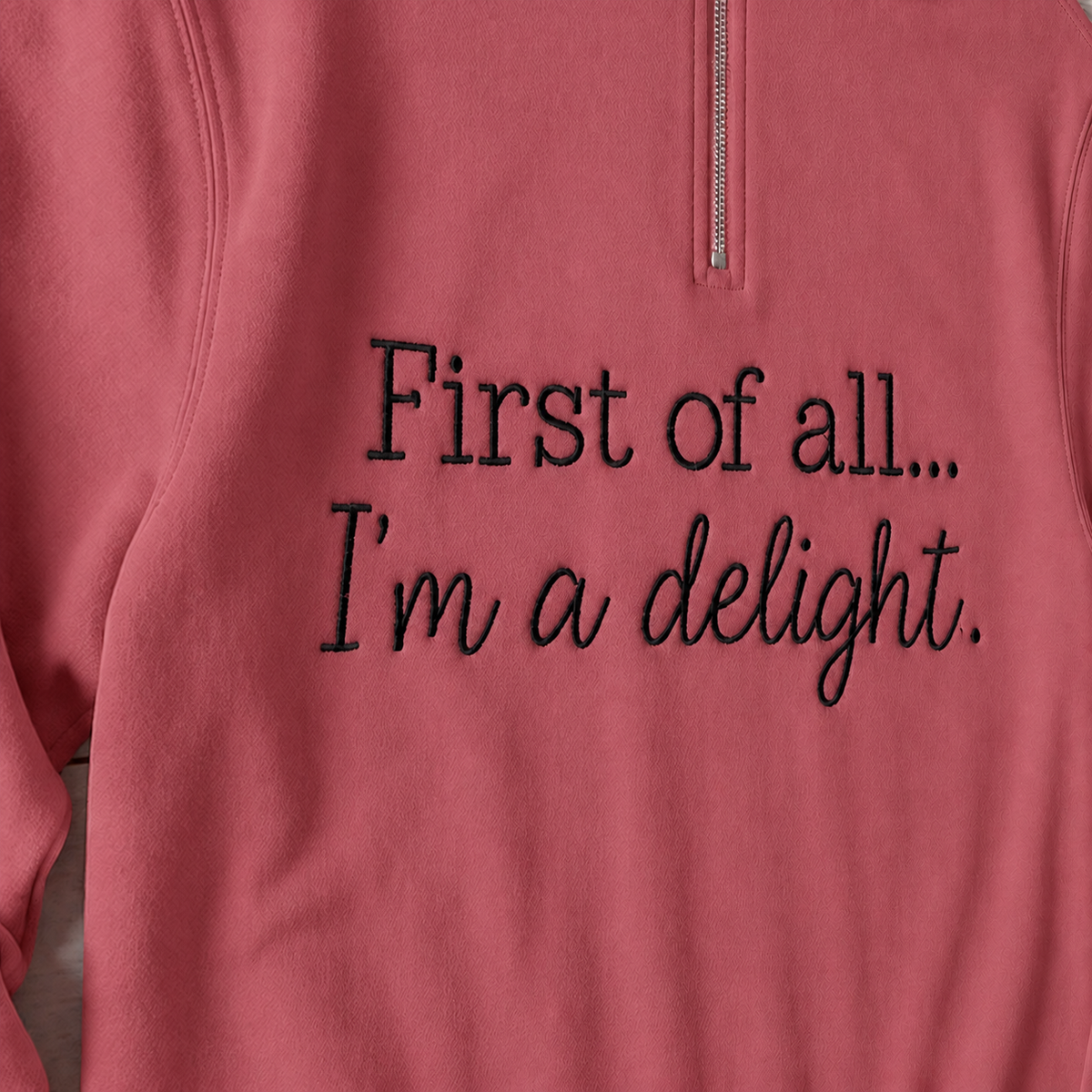 Close-up of enlarged black First of all... I'm a delight. embroidery on Comfort Colors G1580 Crimson quarter-zip