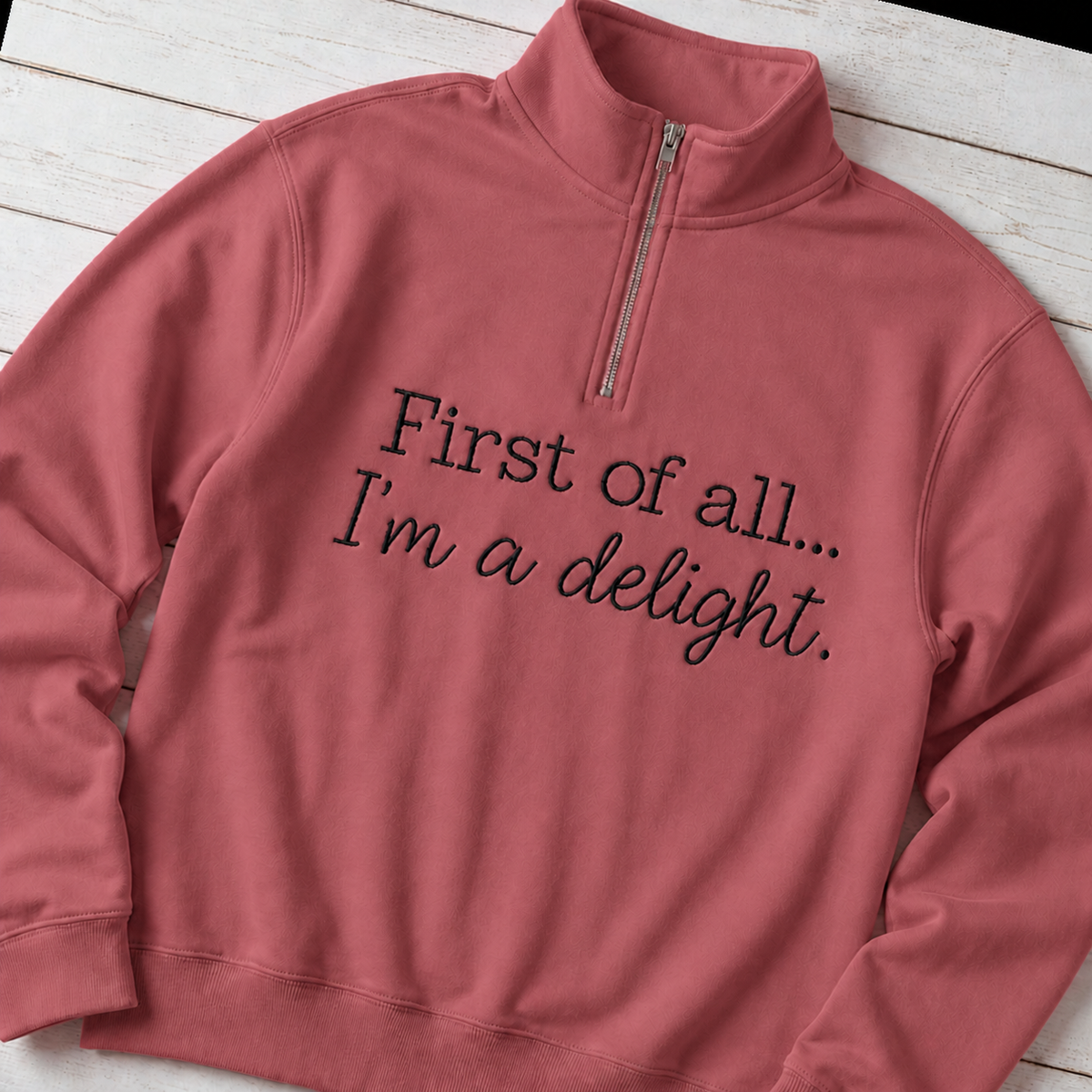 Angled flat lay of Comfort Colors G1580 Crimson quarter-zip with enlarged black First of all... I'm a delight. embroidery