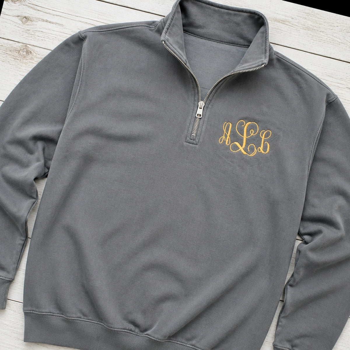 gold script pocket monogram quarter zip styled flat lay