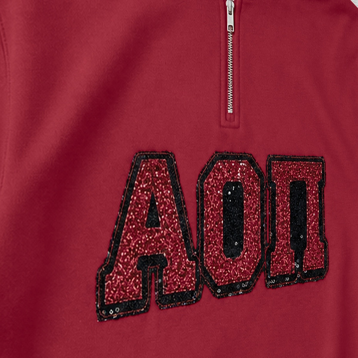 Close-up of the embroidered design on a custom greek letter sequin applique quarter zip pullover