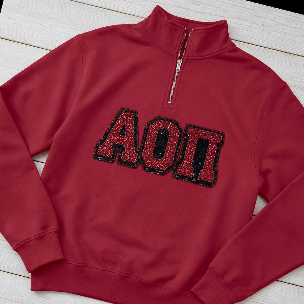 Custom greek letter sequin applique quarter zip pullover folded flat lay