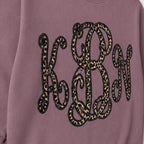 Close-up of the embroidered design on a custom leopard vine monogram crewneck sweatshirt