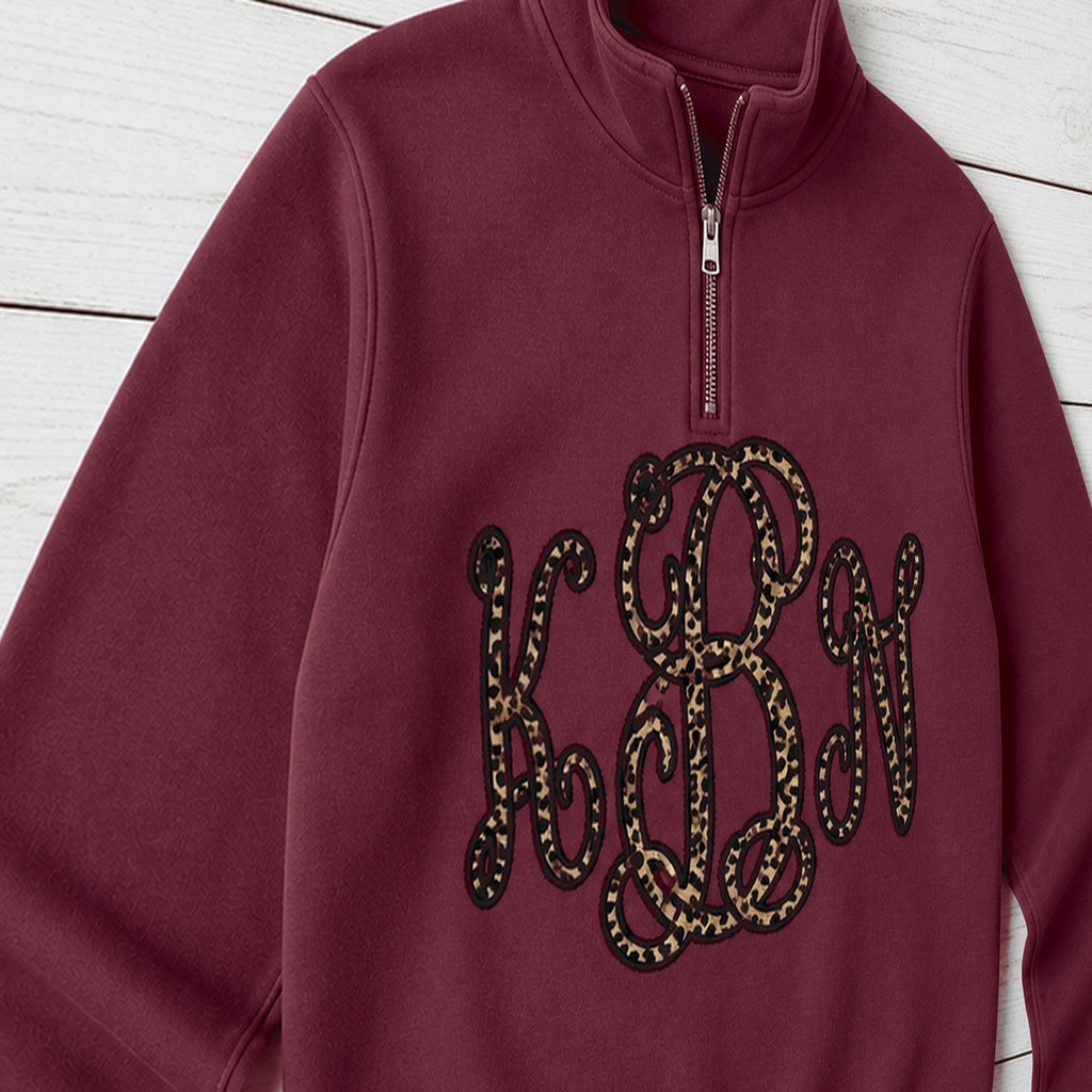Close-up of the embroidered design on a custom leopard vine monogram quarter zip pullover