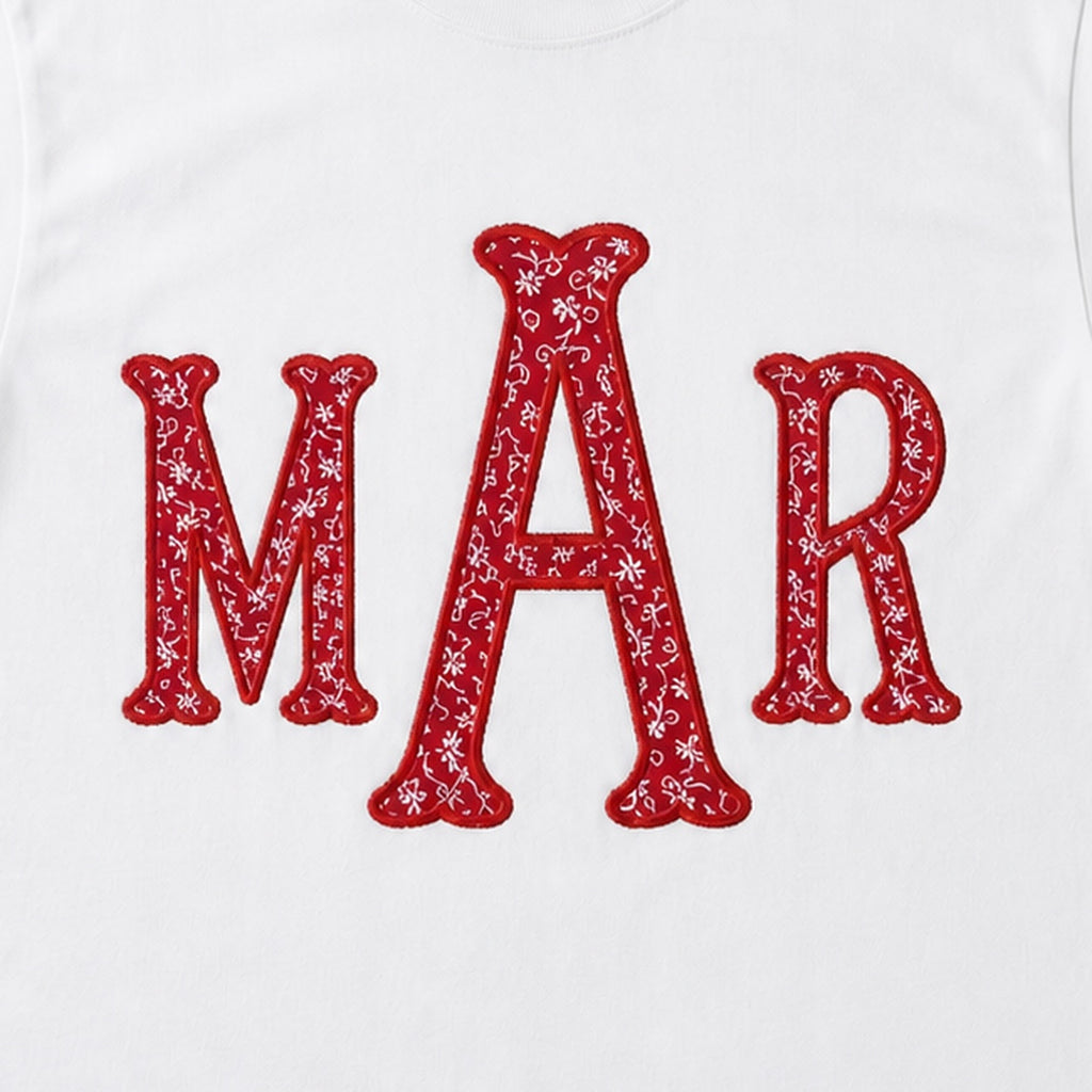 Close-up of the red floral MAR applique monogram and embroidered border