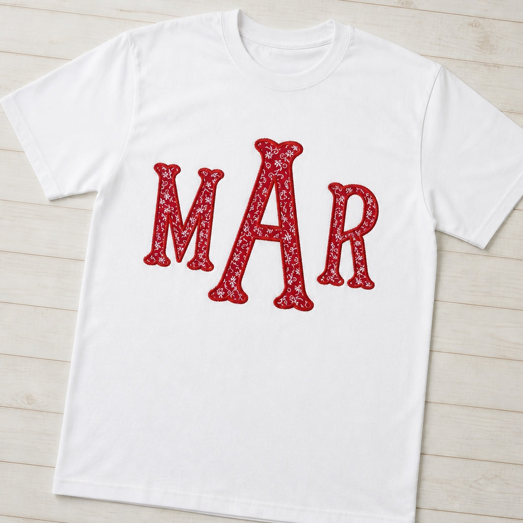 Angled flat lay of a white shirt with an upright red floral MAR monogram