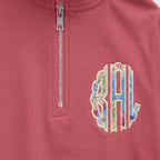 Close-up of the embroidered design on a custom pastel stripe chest monogram quarter zip pullover
