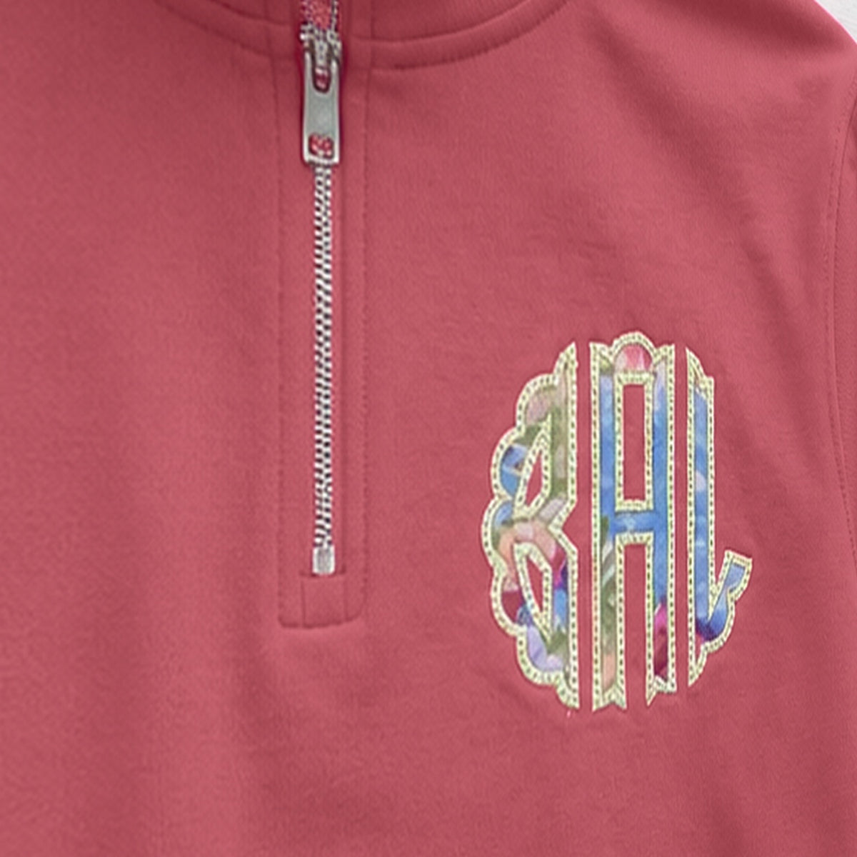 Close-up of the embroidered design on a custom pastel stripe chest monogram quarter zip pullover