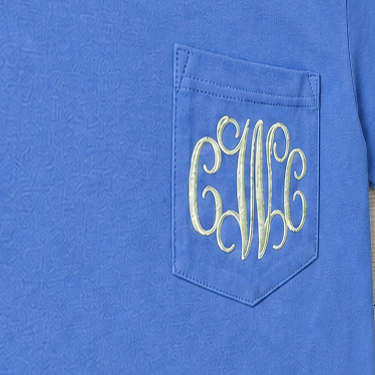 Close-up of the embroidered design on a vine monogram pocket tee